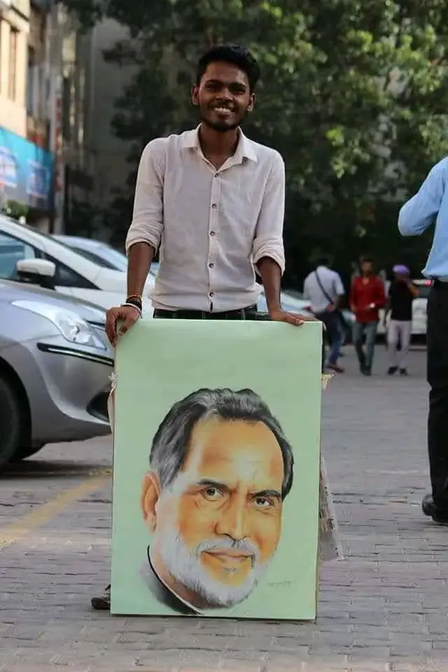 Deepak - Portrait Artist in Delhi Patel Nagar holding large artwork